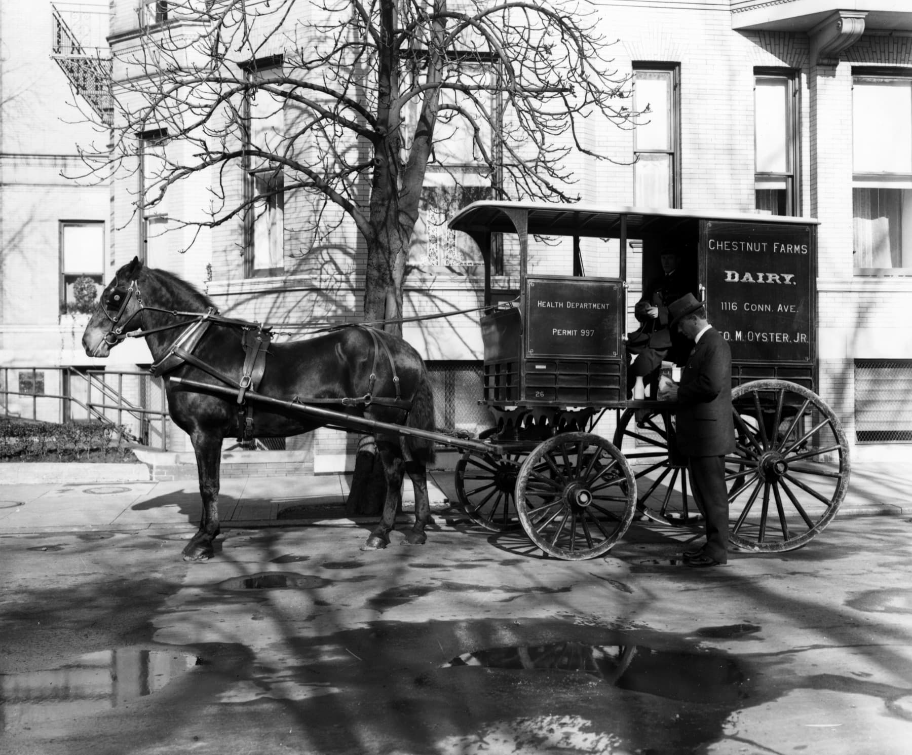 Historic photograph of an inspector examining a milk wagon during dairy inspection work in 1914.